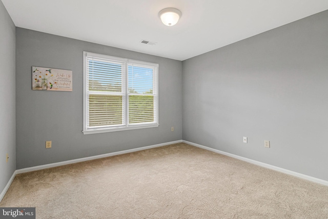 carpeted spare room featuring baseboards