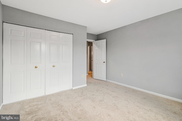 unfurnished bedroom featuring carpet flooring, a closet, and baseboards