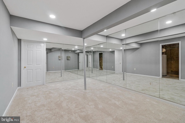 unfurnished bedroom with carpet, recessed lighting, baseboards, and water heater