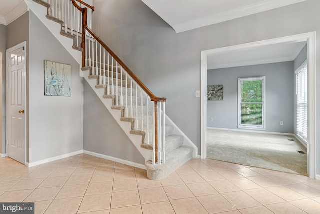 stairs featuring ornamental molding, baseboards, tile patterned flooring, and carpet