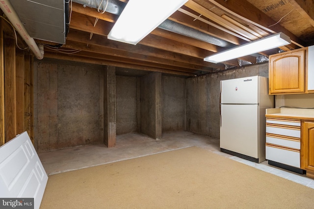 unfinished below grade area featuring freestanding refrigerator