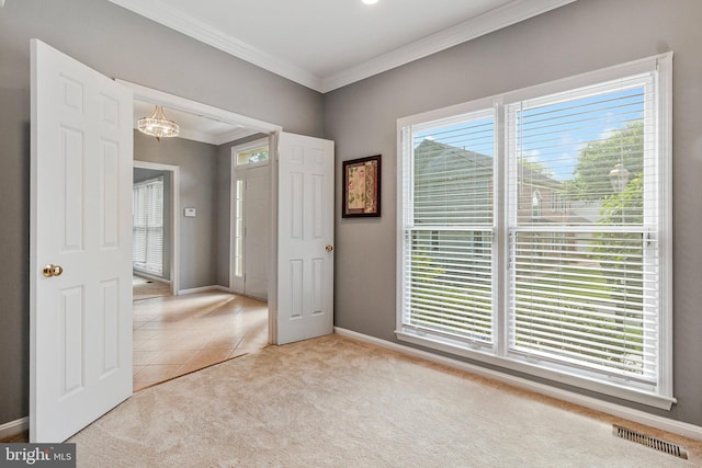 unfurnished bedroom featuring crown molding, a chandelier, carpet, baseboards, and tile patterned flooring