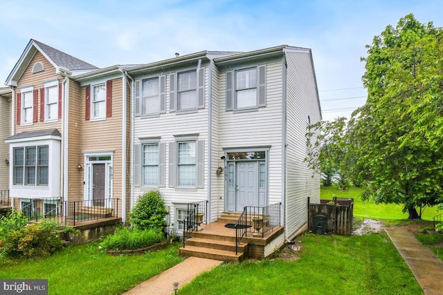townhome / multi-family property with a front lawn