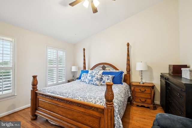 bedroom with light wood-style floors, lofted ceiling, baseboards, and ceiling fan