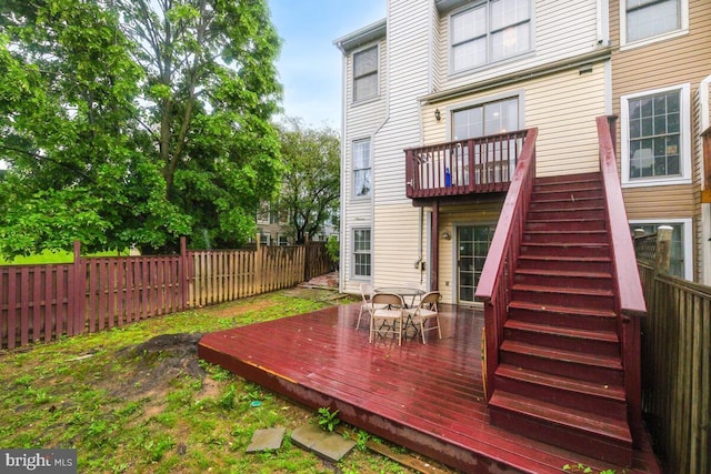 rear view of property with a fenced backyard, a wooden deck, and stairway