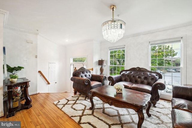 living room featuring crown molding, hardwood / wood-style flooring, and a chandelier