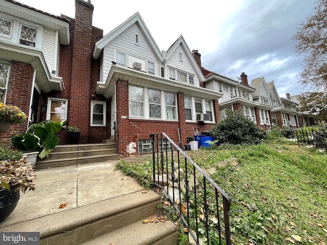 view of front of home with brick siding, a residential view, and cooling unit