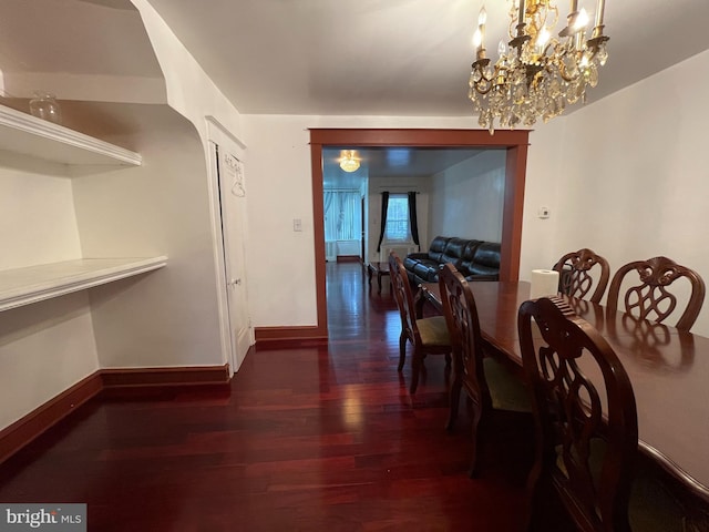 dining area featuring wood finished floors, baseboards, and a chandelier