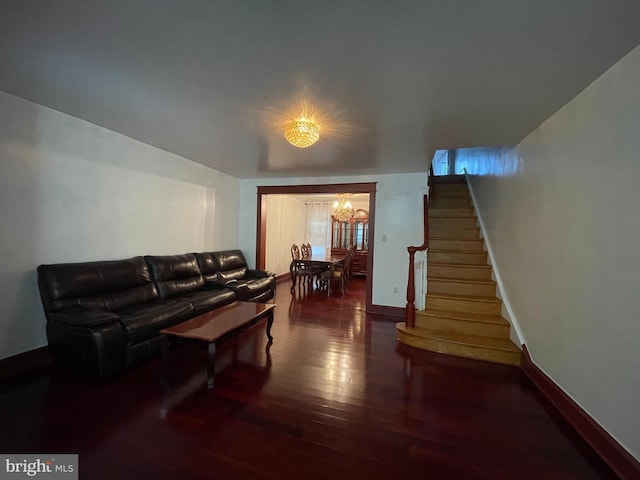 living room featuring a chandelier, wood finished floors, stairs, and baseboards