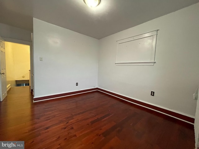 empty room featuring wood finished floors and baseboards