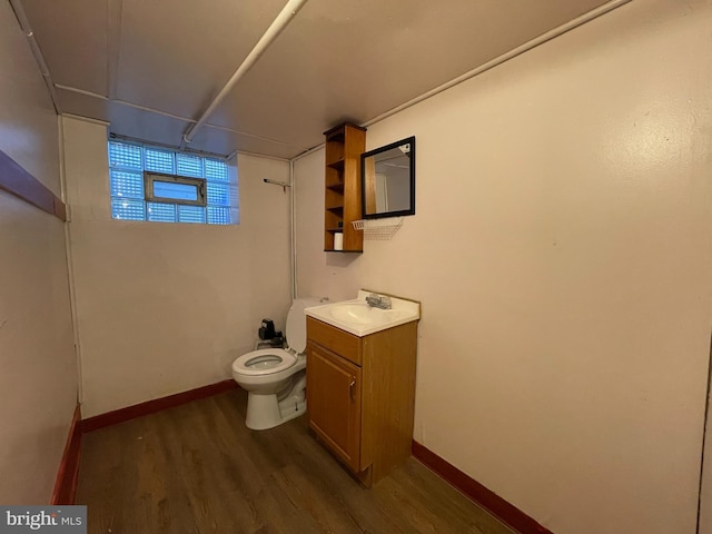 bathroom featuring wood finished floors, vanity, toilet, and baseboards