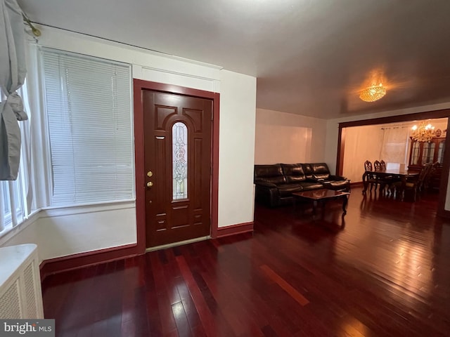 entrance foyer featuring hardwood / wood-style floors, baseboards, and a chandelier