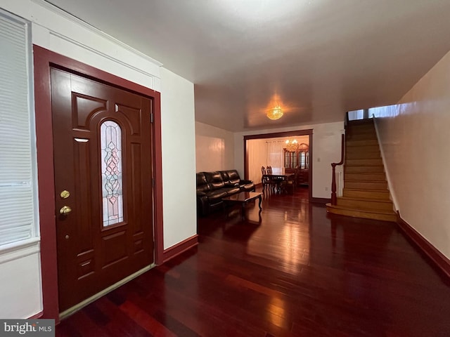 entrance foyer with wood finished floors, baseboards, and stairs