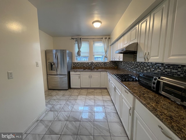 kitchen with stainless steel fridge with ice dispenser, under cabinet range hood, a sink, black gas cooktop, and light marble finish flooring