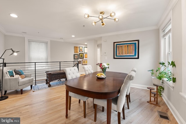 dining space with a chandelier, light wood-style flooring, ornamental molding, plenty of natural light, and baseboards