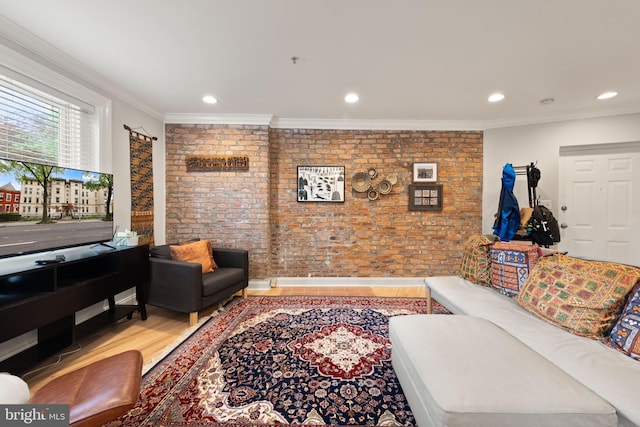 living room with brick wall, crown molding, wood finished floors, and recessed lighting