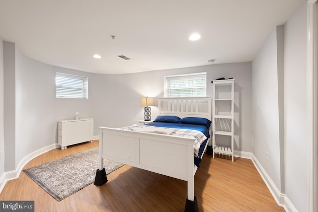 bedroom with wood finished floors, baseboards, and recessed lighting