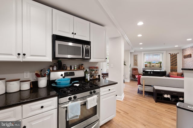 kitchen featuring stainless steel appliances, ornamental molding, white cabinetry, recessed lighting, and open floor plan