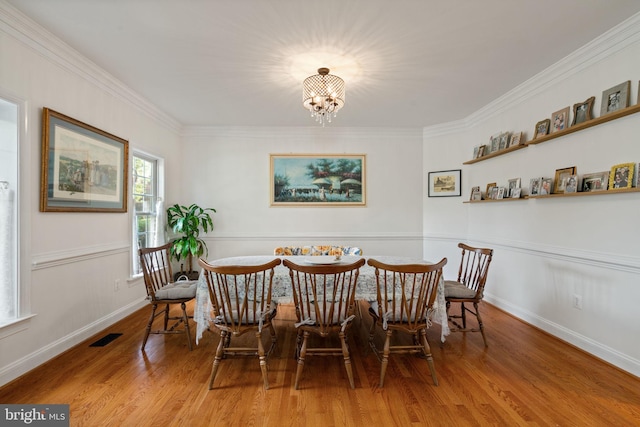 7814 Abbey Oaks Ct, Manassas, VA 20112 - dining area with a chandelier, wood finished floors, crown molding, and baseboards