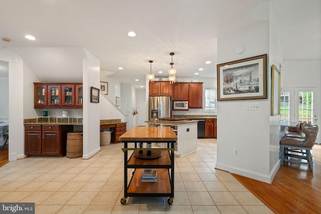 7814 Abbey Oaks Ct, Manassas, VA 20112 - kitchen featuring stainless steel appliances, recessed lighting, glass insert cabinets, decorative light fixtures, and baseboards