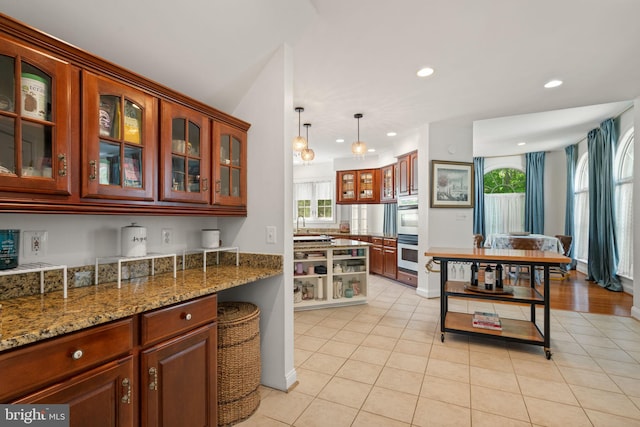 7814 Abbey Oaks Ct, Manassas, VA 20112 - kitchen with light tile patterned floors, double oven, recessed lighting, glass insert cabinets, and light stone counters