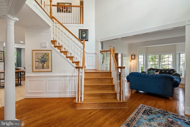 7814 Abbey Oaks Ct, Manassas, VA 20112 - stairway with wood finished floors, a high ceiling, crown molding, a decorative wall, and a wainscoted wall