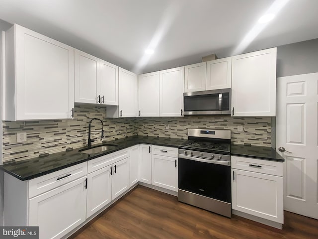 2059 E Atlantic St, Philadelphia, PA 19134 - kitchen featuring stainless steel appliances, a sink, dark countertops, and white cabinetry