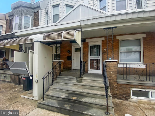 2059 E Atlantic St, Philadelphia, PA 19134 - entrance to property with board and batten siding, brick siding, and covered porch