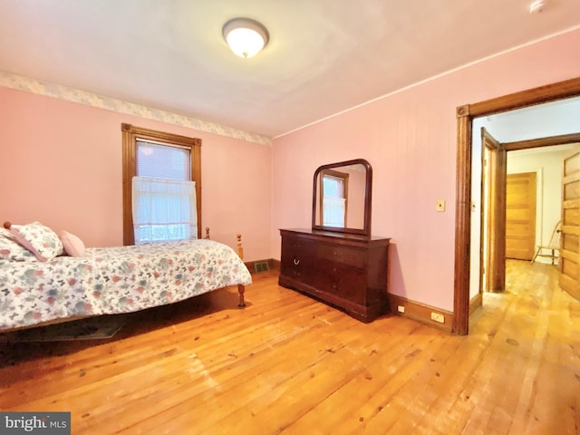 bedroom with hardwood / wood-style flooring and baseboards