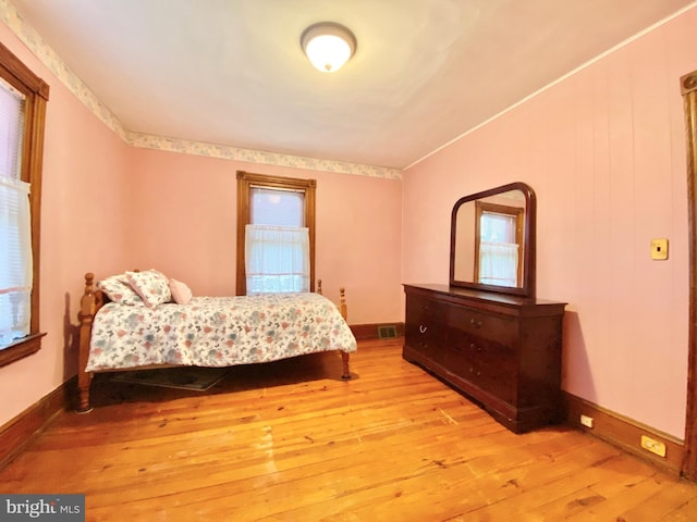 bedroom with hardwood / wood-style flooring and baseboards