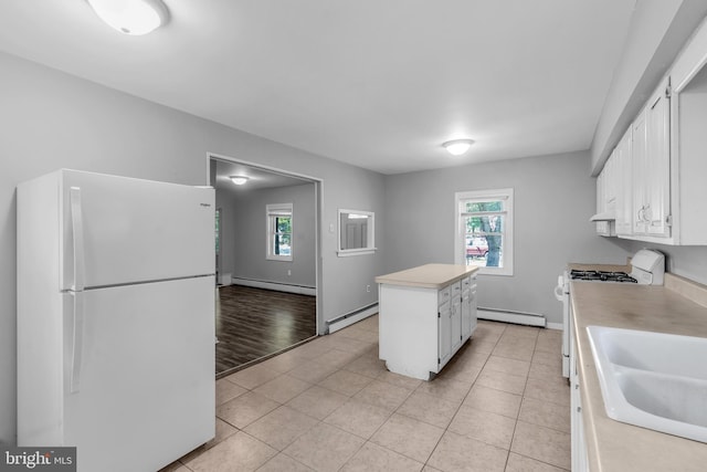 102 Sunset St, Browns Mills, NJ 08015 - kitchen with white appliances, a baseboard radiator, light countertops, and plenty of natural light