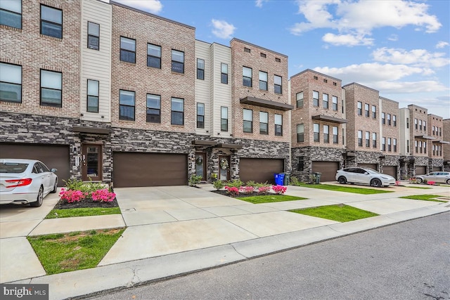 view of building exterior with a residential view, a garage, and driveway