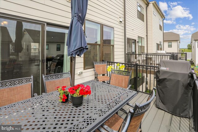 deck with outdoor dining space and grilling area