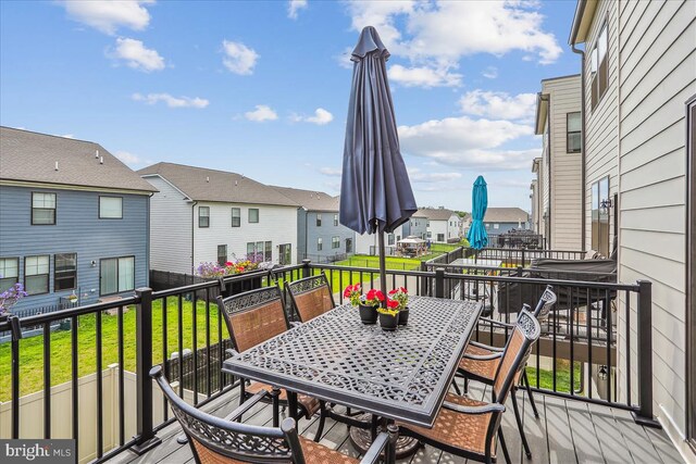wooden deck featuring a residential view, a yard, and outdoor dining area