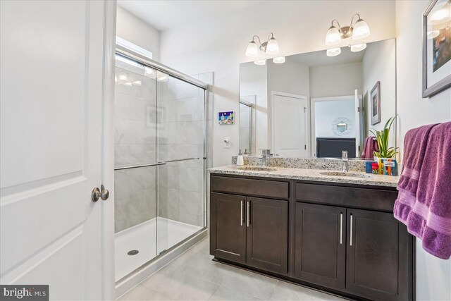full bath featuring a shower stall, double vanity, and tile patterned floors