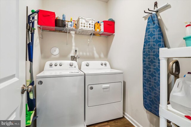laundry room with washer and dryer, dark wood-type flooring, and baseboards