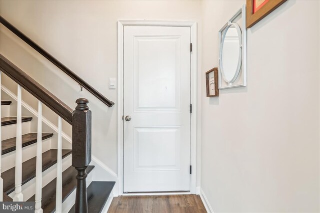staircase with wood finished floors and baseboards