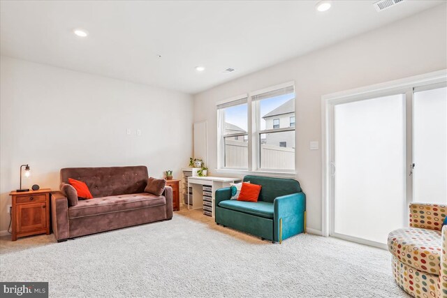 carpeted living room with recessed lighting and baseboards