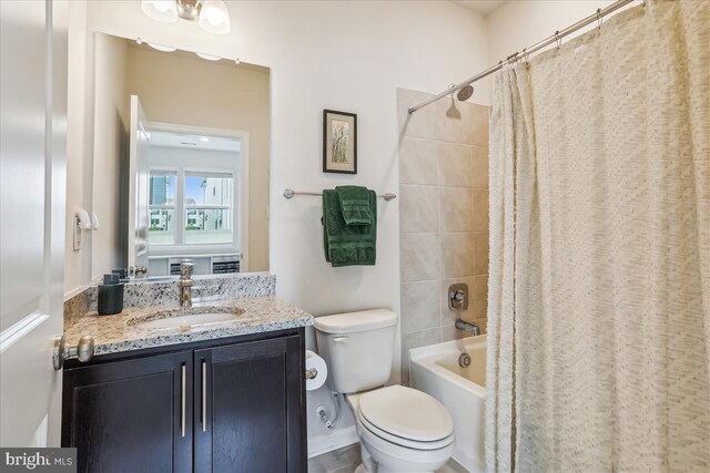 bathroom with toilet, vanity, and shower / bath combo