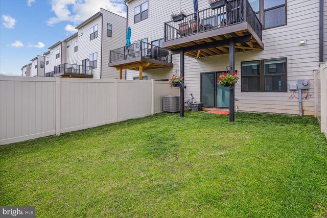 view of yard featuring a balcony, central AC, and a residential view