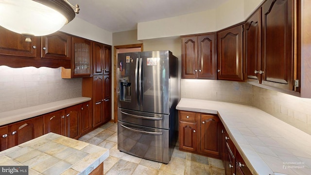 955 Lucabaugh Mill Rd, Westminster, MD 21157 - kitchen with stainless steel fridge, decorative backsplash, tile counters, and glass insert cabinets