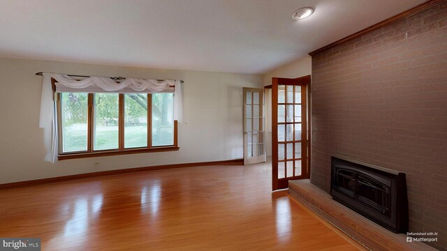 955 Lucabaugh Mill Rd, Westminster, MD 21157 - unfurnished living room featuring light wood-style floors, baseboards, a large fireplace, and french doors