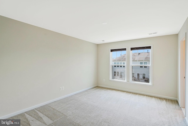 unfurnished room with baseboards and light carpet