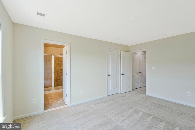 unfurnished bedroom featuring carpet, baseboards, and ensuite bath