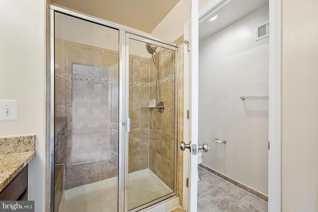 bathroom featuring a shower stall, vanity, baseboards, and toilet