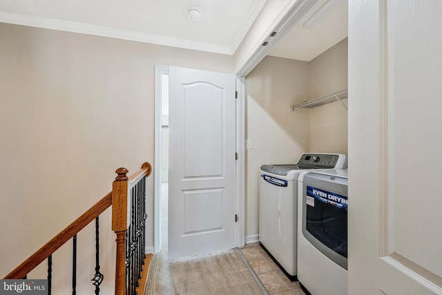 clothes washing area featuring washing machine and clothes dryer and crown molding