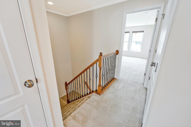corridor with an upstairs landing, carpet flooring, ornamental molding, and recessed lighting