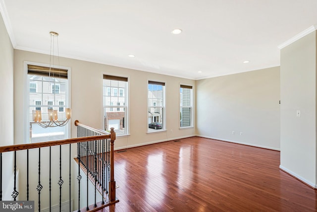 unfurnished room featuring crown molding, wood finished floors, a chandelier, baseboards, and recessed lighting