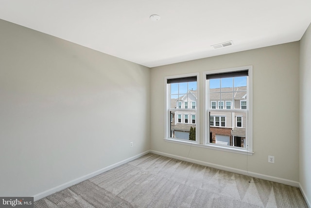empty room with baseboards and light colored carpet