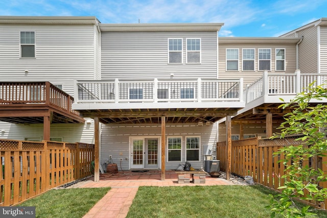 rear view of house with a wooden deck, a patio area, and cooling unit